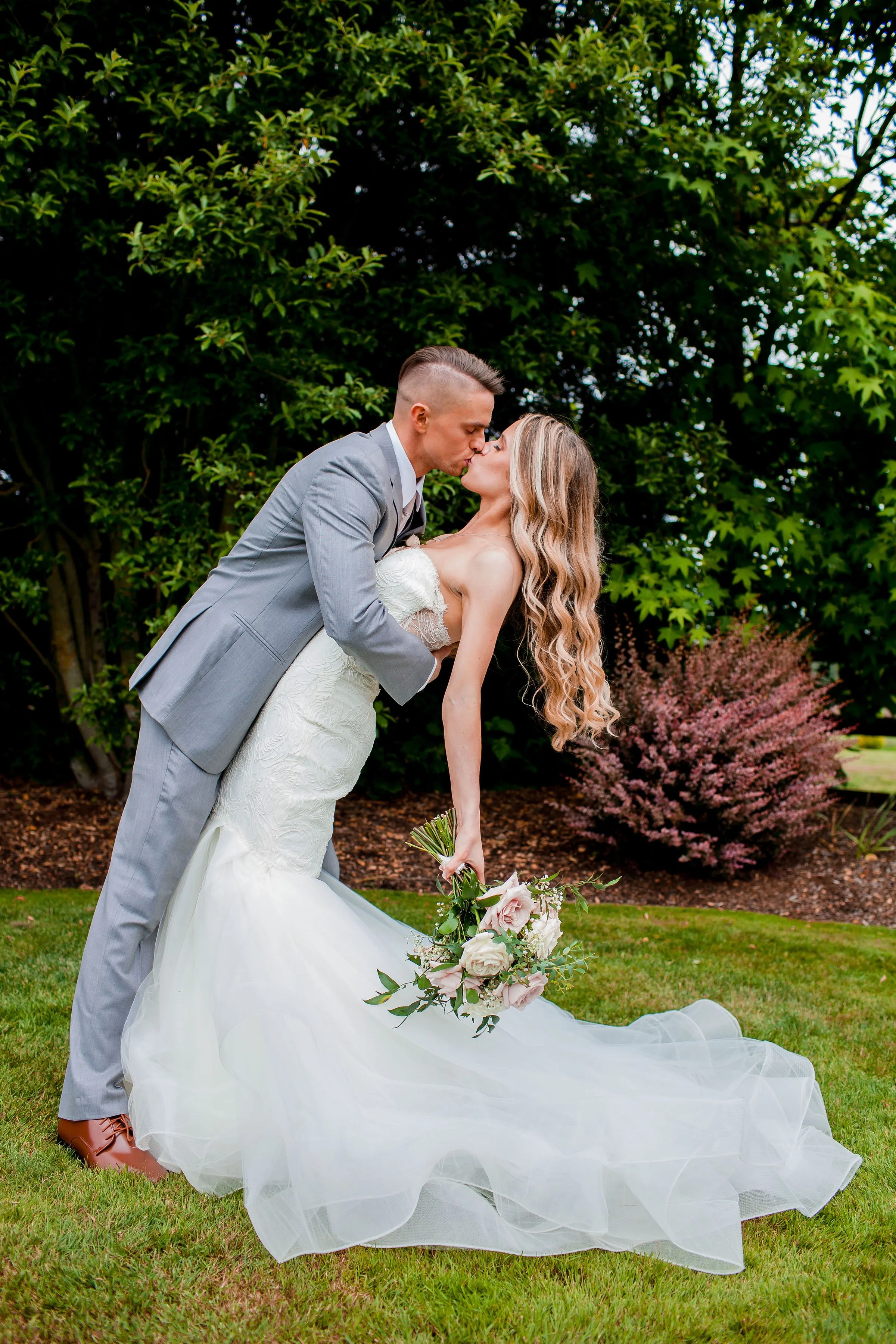 bride groom dip kiss mountain view manor enumclaw washington - Weddings at Mountain View Manor Bride and groom share a romantic dip kiss on the lawn at Mountain View Manor wedding venue in Enumclaw Washington near Seattle, with the bride in a strapless mermaid gown holding a blush rose bouquet