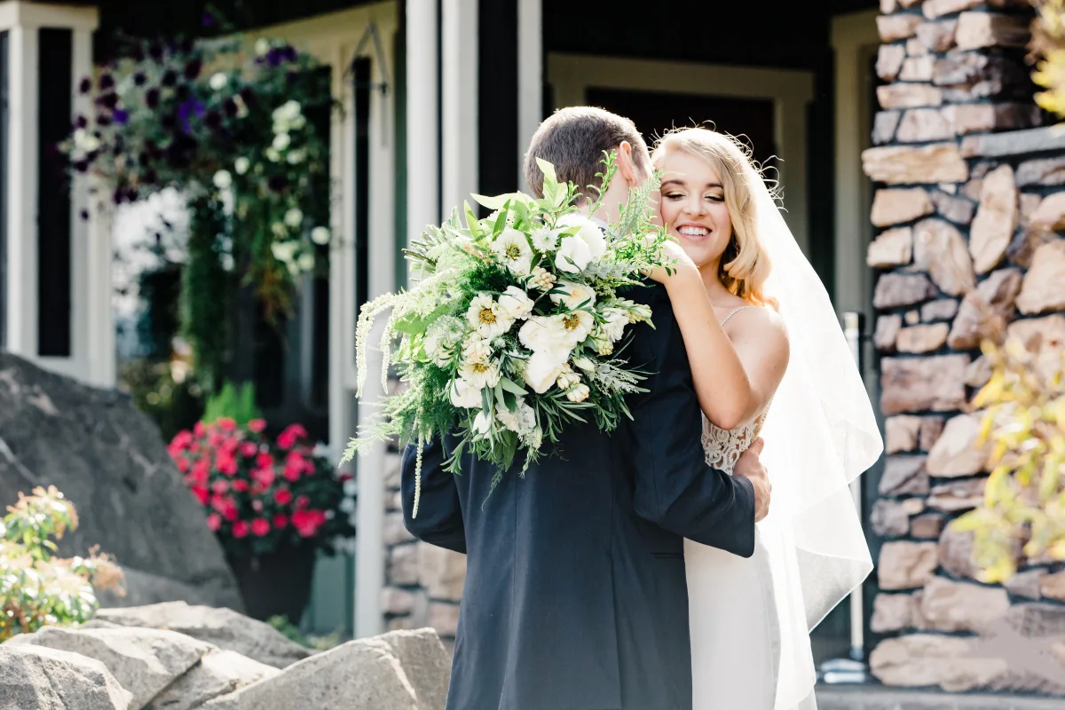 bride groom first look embrace mountain view manor - Preferred Vendors Bride smiling joyfully while embracing groom during first look at Mountain View Manor wedding venue in Enumclaw Washington near Seattle, bride holding lush white and greenery bouquet