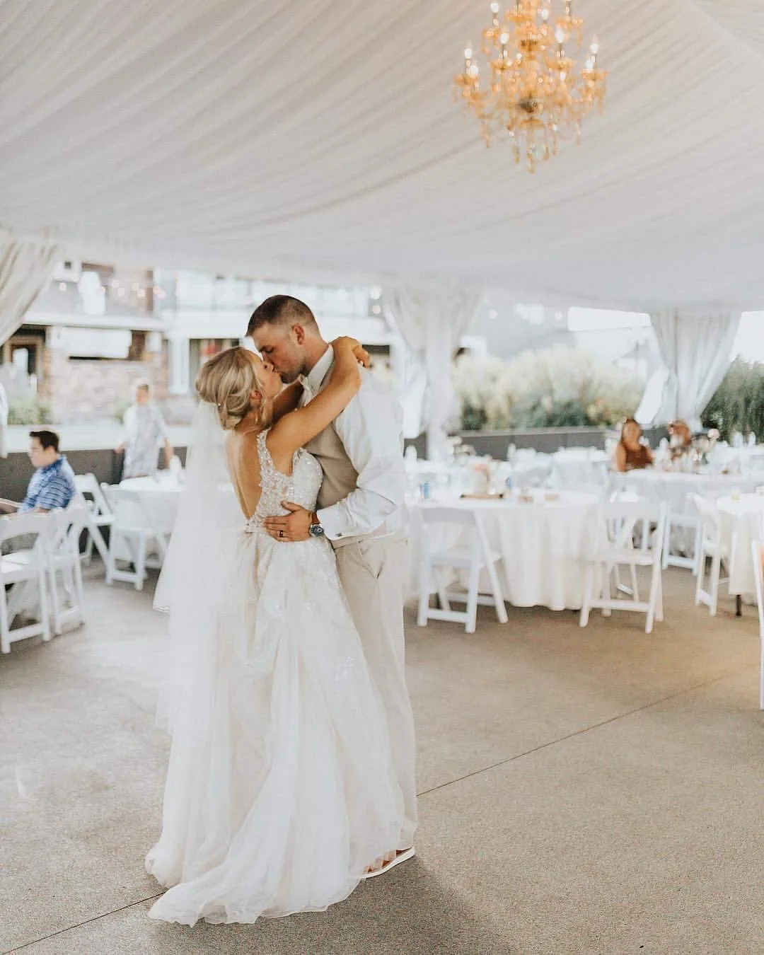 first dance kiss wedding reception mountain view manor - Frequently Asked Questions Bride and groom share a first dance kiss under a chandelier in the elegant white tent reception space at Mountain View Manor wedding venue in Enumclaw Washington near Seattle