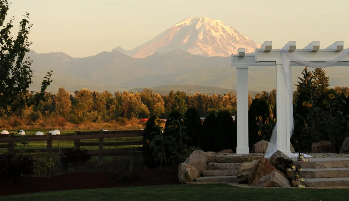 mountain view manor wedding venue enumclaw washington mount rainier 1 - Private Events Outdoor wedding ceremony pergola with sunflowers and stone steps framing a stunning view of snow-capped Mount Rainier at Mountain View Manor wedding venue in Enumclaw Washington near Seattle