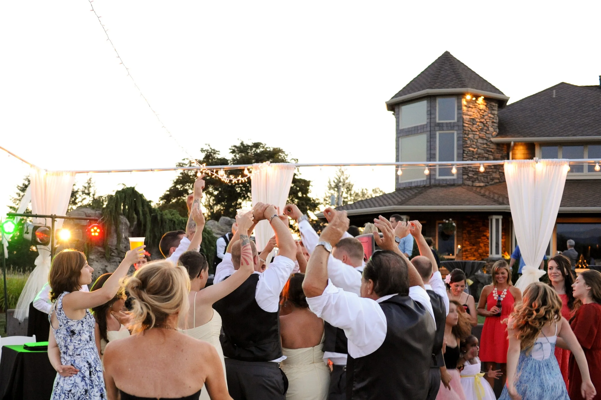 outdoor wedding reception dancing mountain view manor enumclaw - Frequently Asked Questions Wedding guests raise their hands and dance together on the outdoor reception dance floor at Mountain View Manor wedding venue in Enumclaw Washington near Seattle