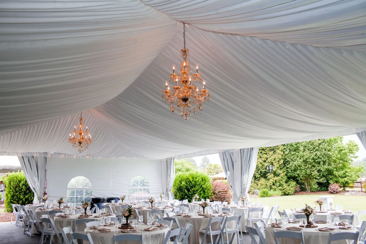 wedding reception tent chandeliers mountain view manor enumclaw 1 - Mountain View Manor Elegant outdoor wedding reception tent with crystal chandeliers and white draped ceiling at Mountain View Manor wedding venue in Enumclaw Washington near Seattle